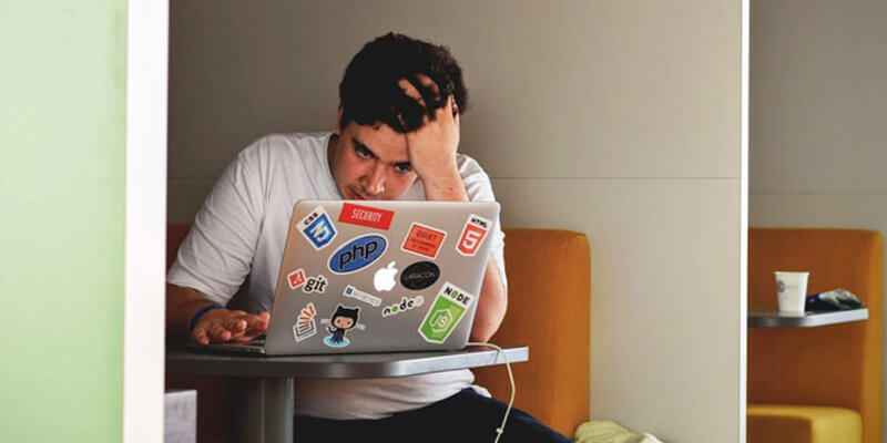 Frustrated man looks at laptop