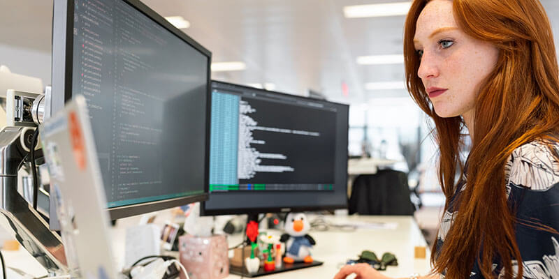 Female engineer coding on computer