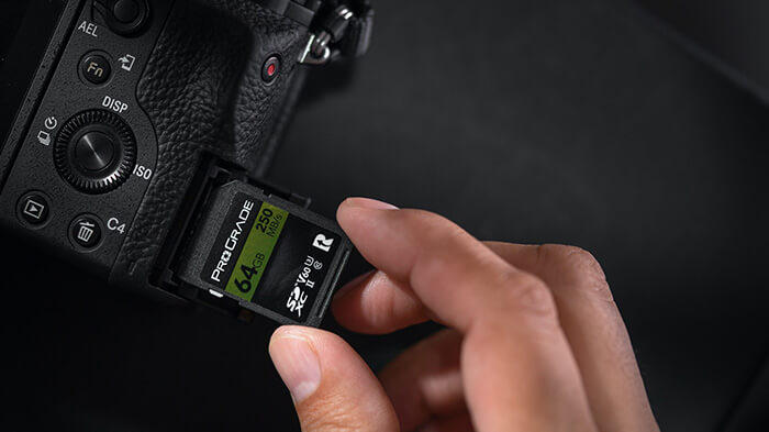 사진작가가 카메라에 SD 카드를 삽입하는 모습