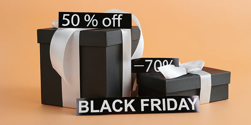 Two black gift boxes on an orange background advertise a Black Friday sale