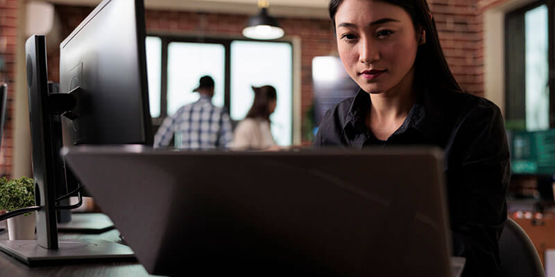 Een Aziatische vrouw stuurt een gecodeerd bestand op haar computer