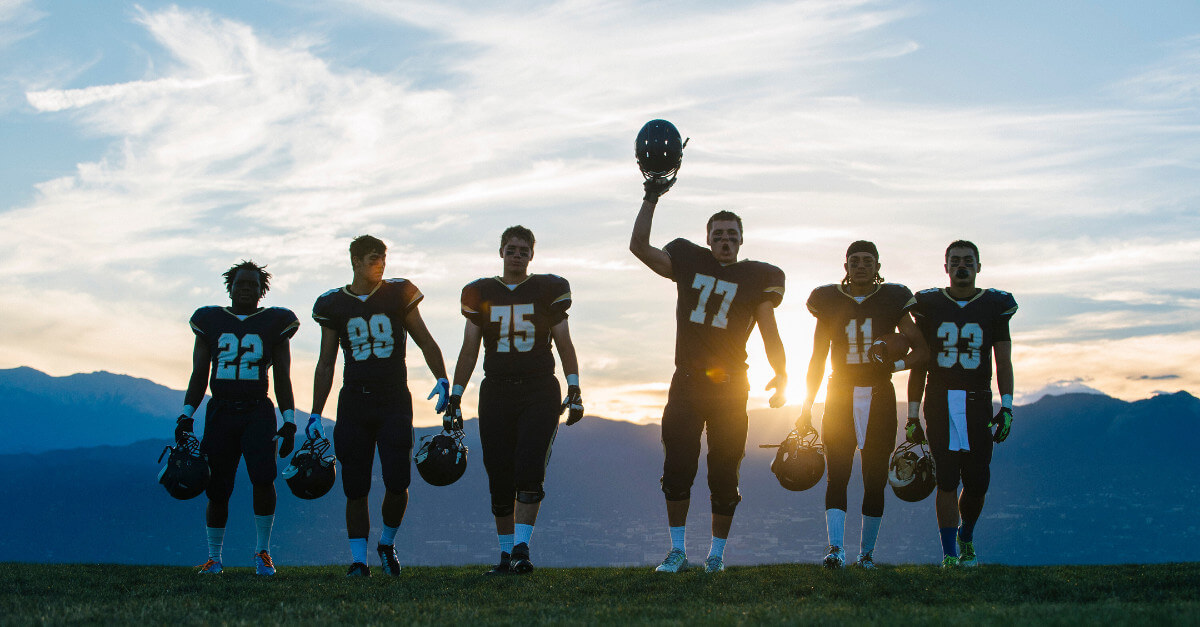 Analítica deportiva en las industrias: Equipo de fútbol al atardecer, mostrando el rendimiento de los atletas basado en datos.